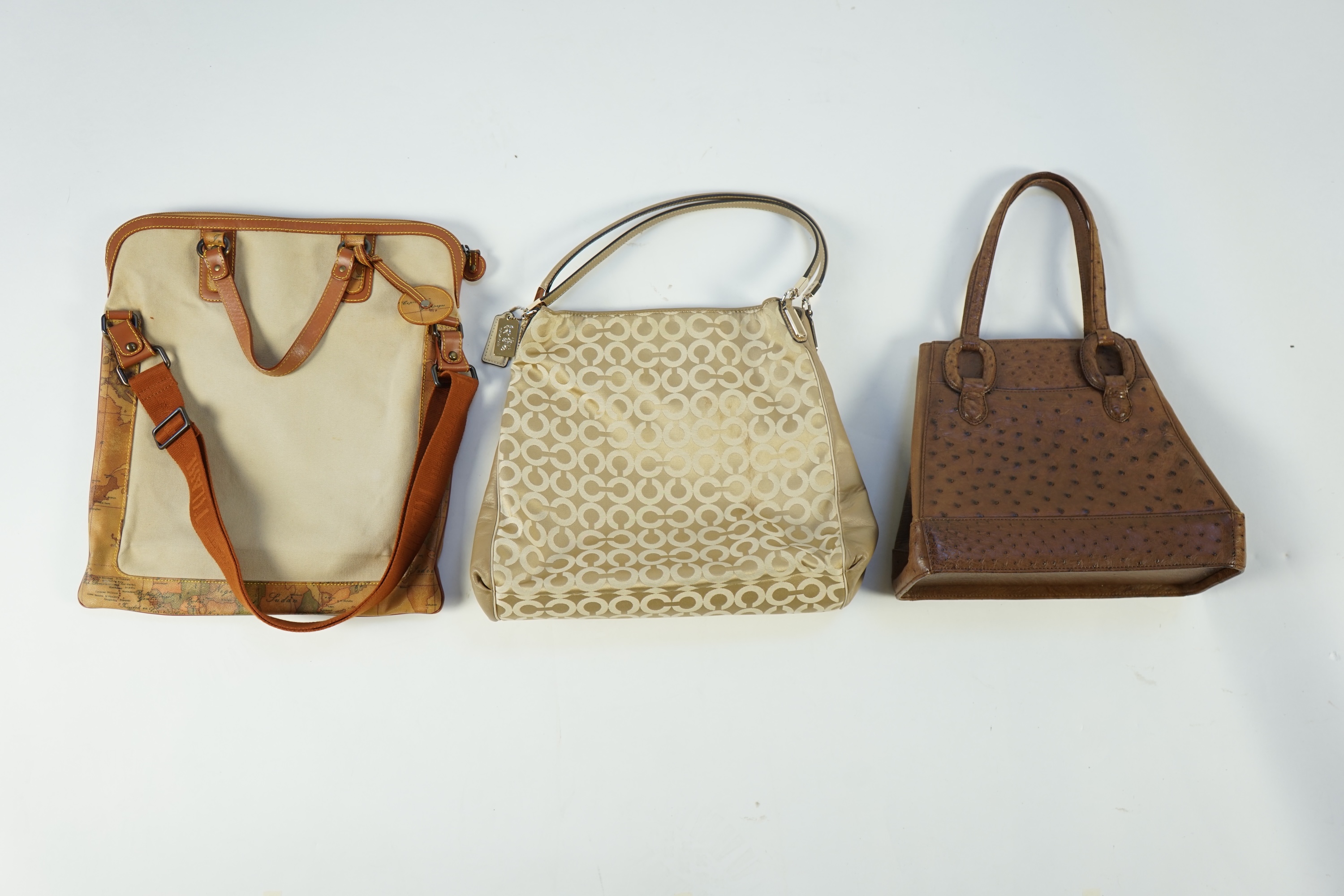 Three handbags, including Tilasse Alviero Martini canvas and leather tote, a monogram Coach tote with dust bag and a Kristar Croco brown ostrich effect leather shoulder bag